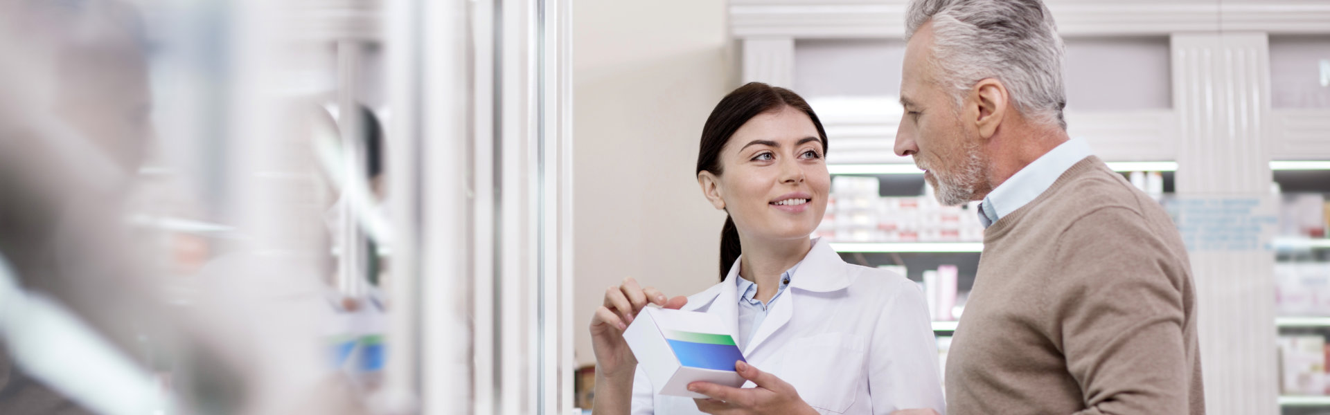 female pharmacist assisting an elderly man